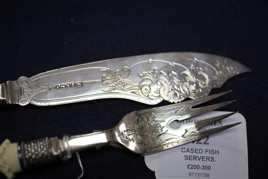 A cased small pair of Victorian carved ivory handled and silver fish servers, knife 9.75in.